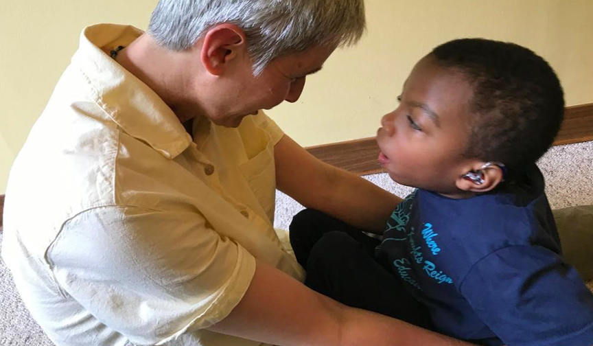 Jutta interacting with a six-year old boy sitting on the floor
